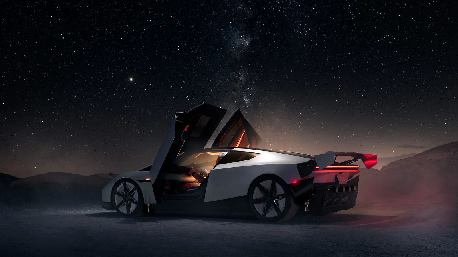 The full Tesla Roadster at night with its doors raised beneath a star-filled sky.